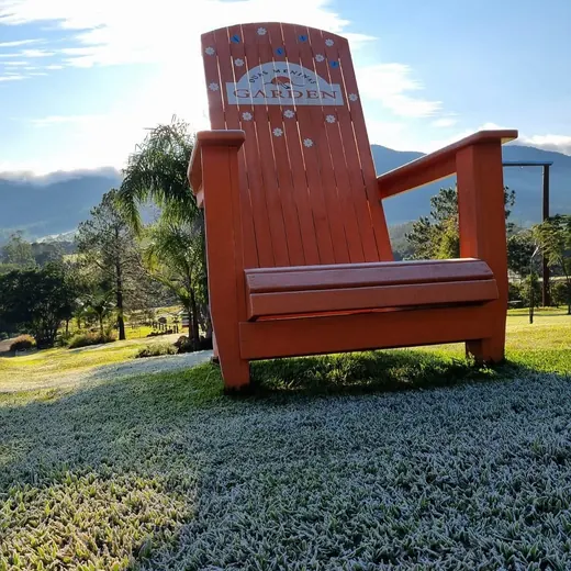 Cadeira gigante vermelha com a logo do Garden no jardim