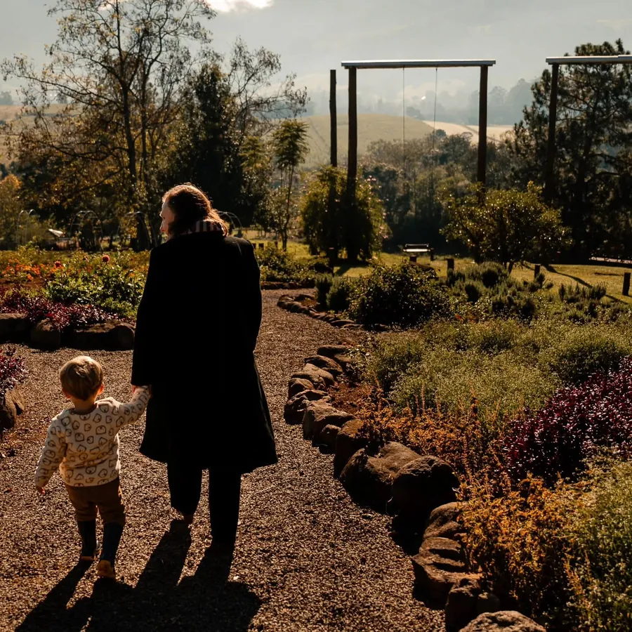 Família caminhando pelo jardim ao entardecer